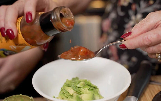 A spoonful of Dyana's Aji being poured onto spoon to make guacamole.